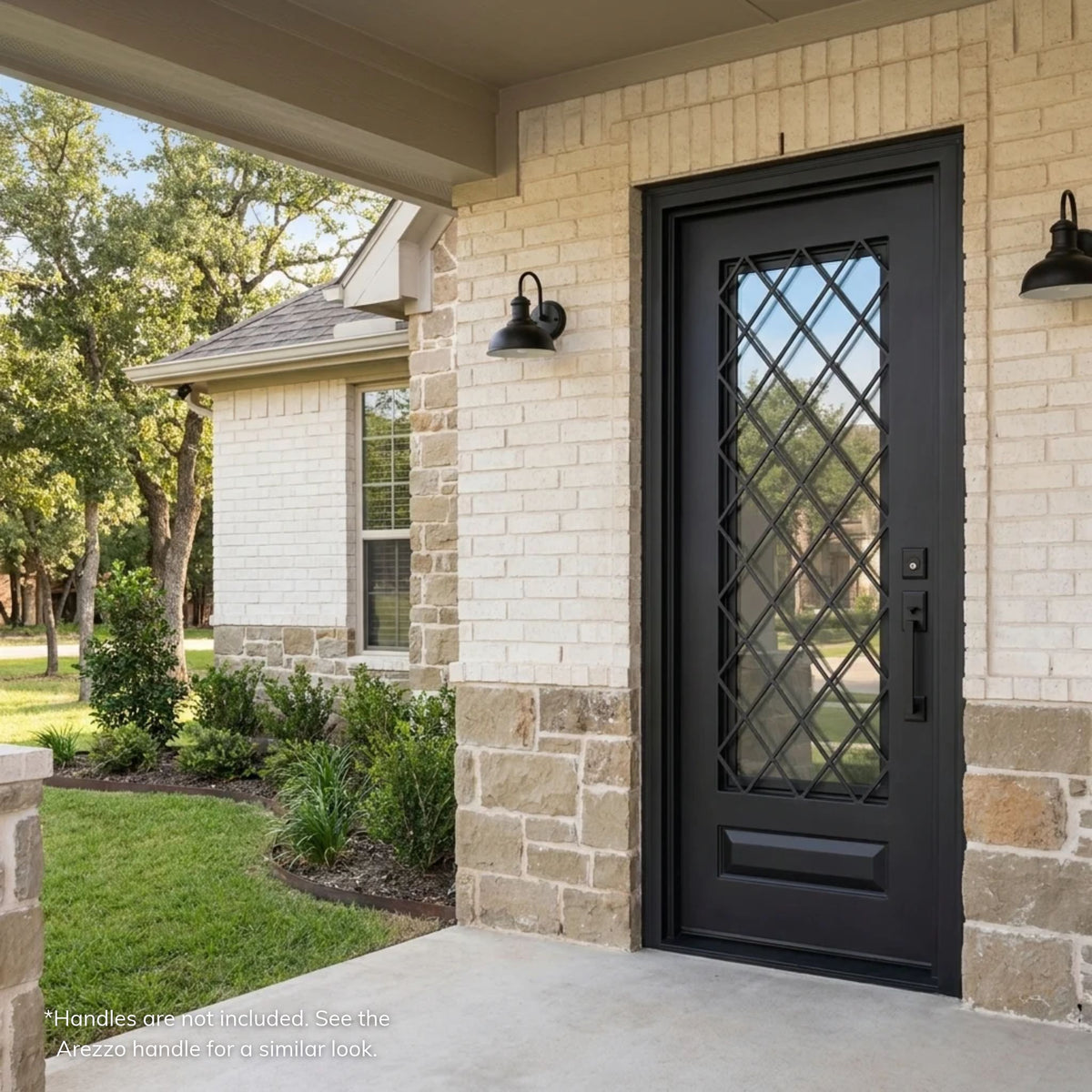 Anna black wrought iron single entry door with diamond lattice ironwork over clear glass and a raised bottom panel, on a cream brick and stone ranch home with a covered porch