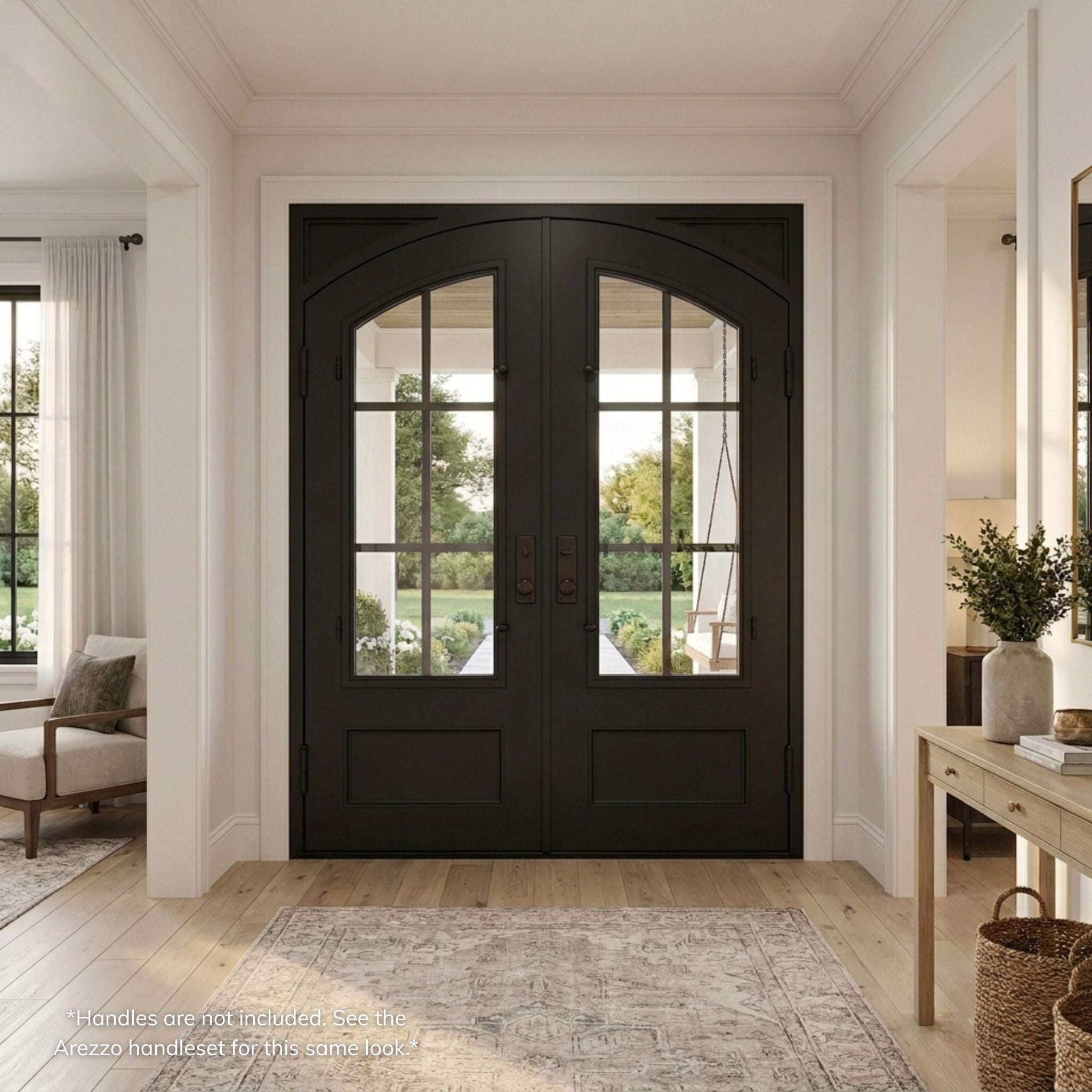 Elizabeth double iron entry door, matte black finish with arched divided-lite glass panels, viewed from the interior of a bright farmhouse-style foyer with wood flooring