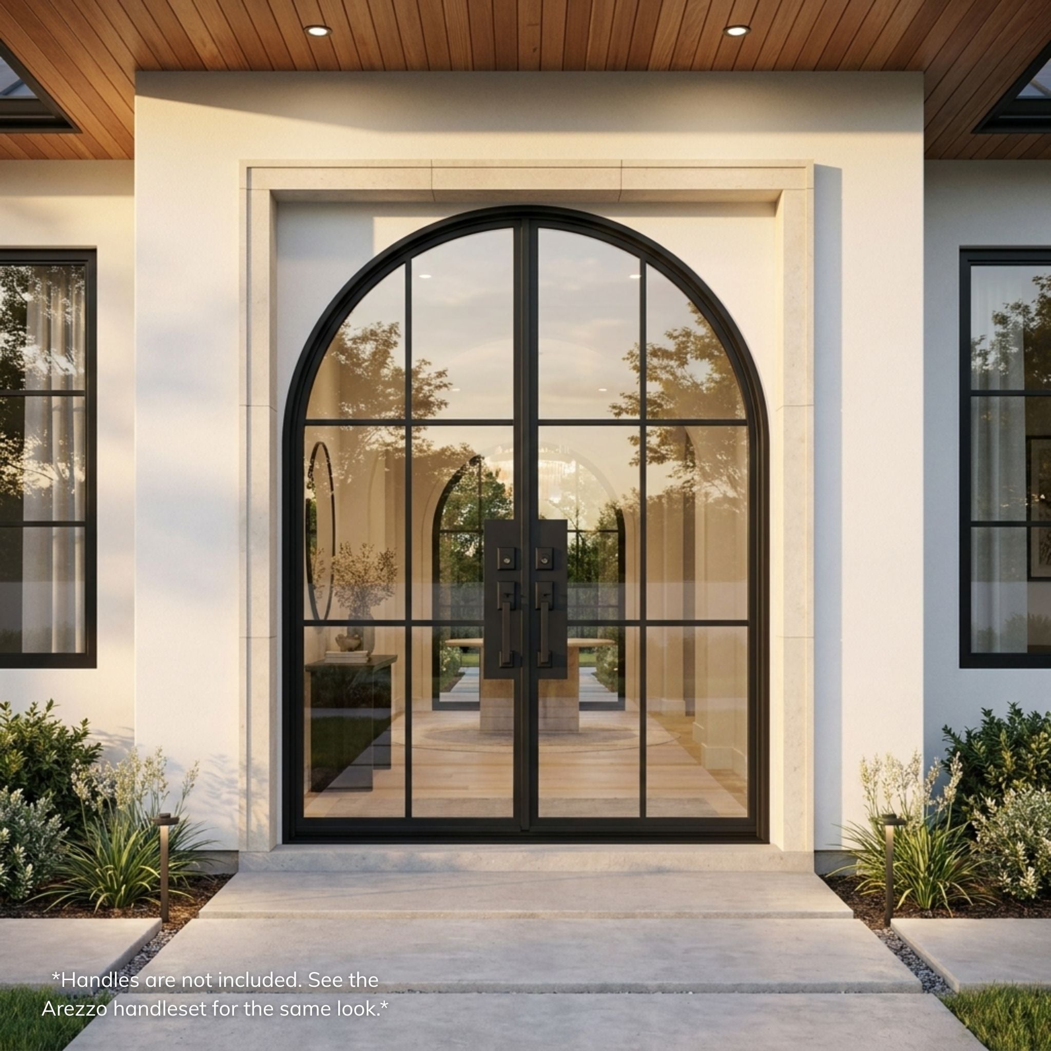 French steel 6-lite arch top double entry door, matte black finish with full-view clear glass, installed on a white stucco home exterior with covered entry