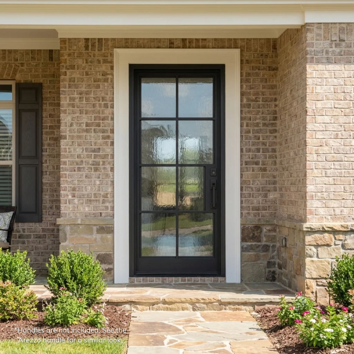 George black wrought iron single entry door with an 8-lite textured glass grid, installed on a brick ranch-style home with a stone wainscot and white trim surround