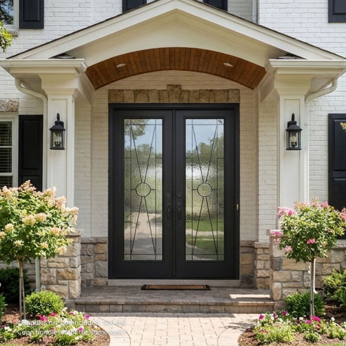 Hillford fiberglass double entry door in a matte black finish with full-lite decorative glass panels featuring a diagonal X pattern and circular medallion, installed on a stone and brick home.