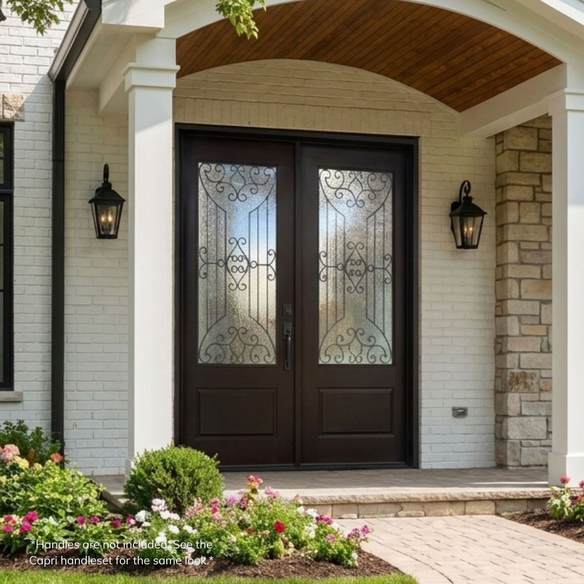 Jupiter fiberglass double entry door in a dark espresso finish with 3/4-lite decorative glass panels featuring an arched scrollwork design, installed beneath an arched wood-paneled porch ceiling on a white brick and stone home.