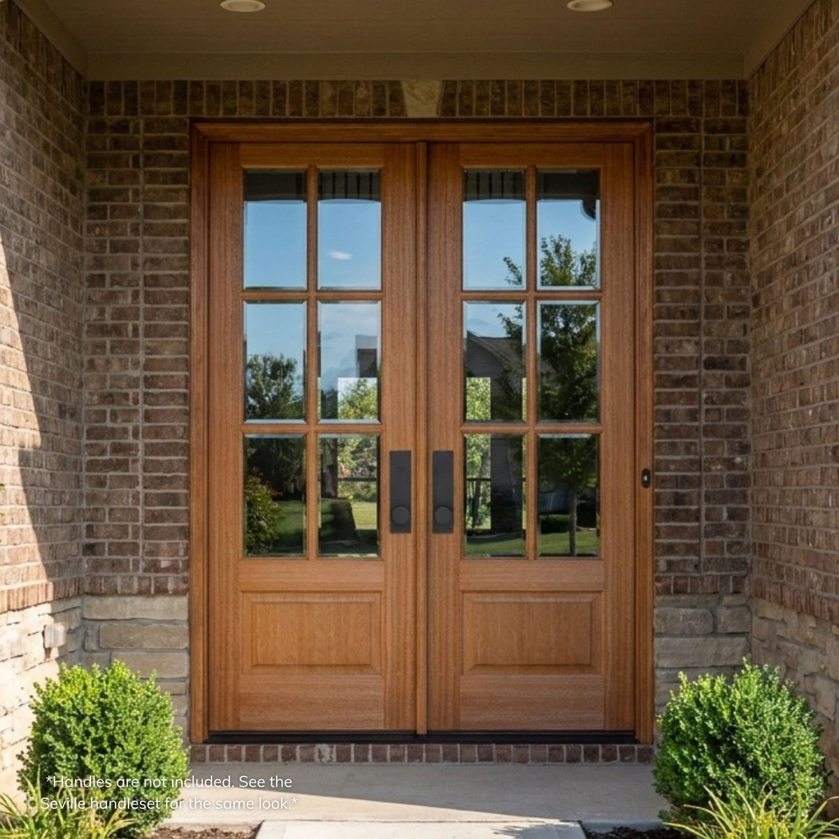 Mahogany double entry door in a natural wood finish, featuring a 6-lite clear glass  with wood mullions on each leaf over a raised panel lower section, installed on a brick home.