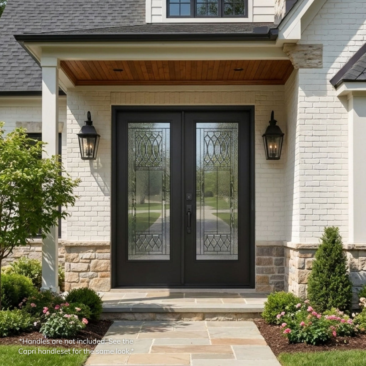 Regency fiberglass double entry door in a prefinished black finish with full-lite decorative glass panels featuring an oval lattice pattern, installed on a stone and brick home with a gabled roofline.