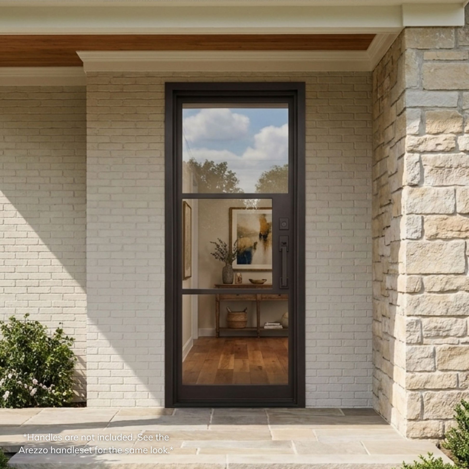 Sawyer iron single entry door, matte black finish with 3-panel clear glass, installed on a stone home exterior with covered entry