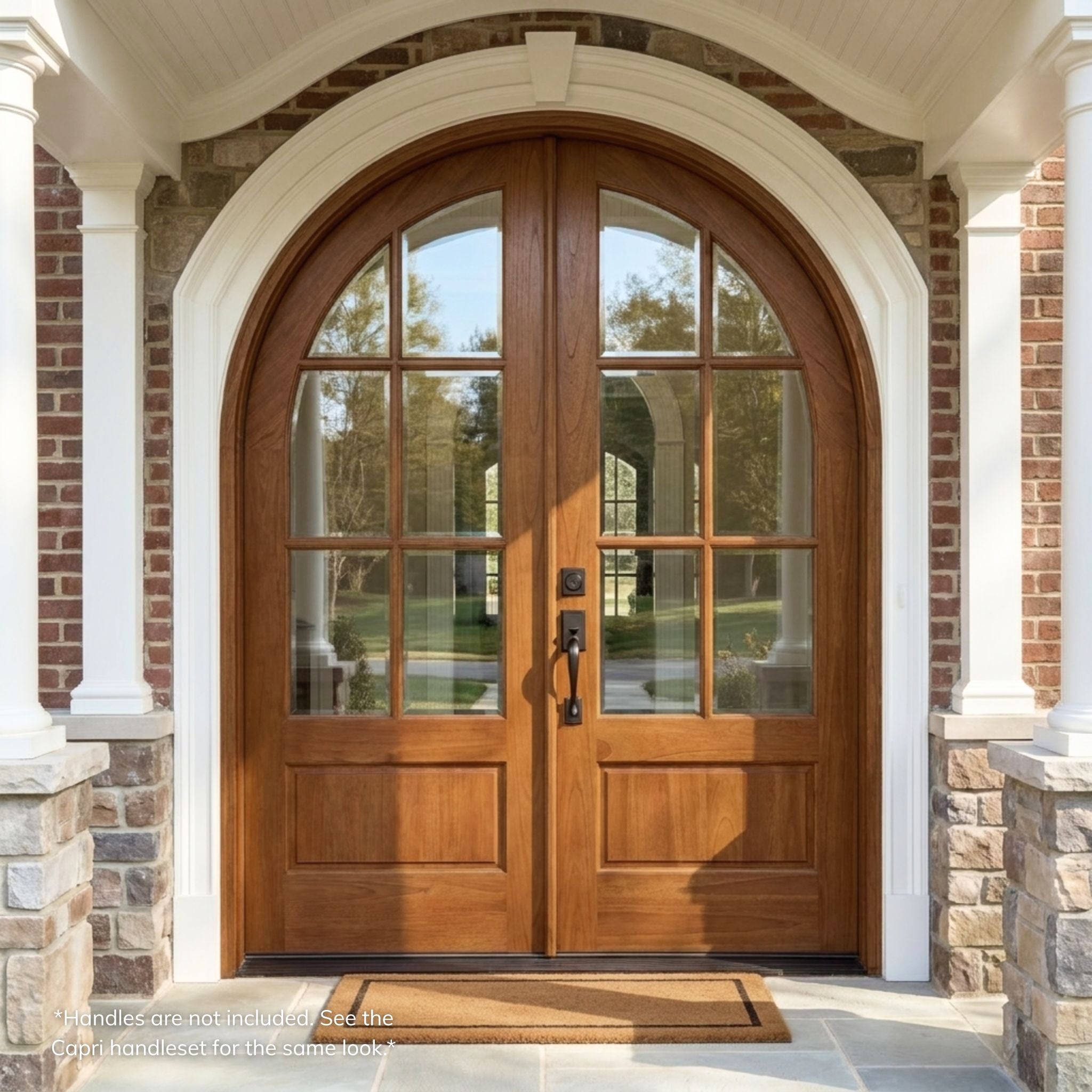Weathercraft torrefied mahogany double entry door, 6-lite arch top design with clear glass, wood grain finish, installed on a brick and stone home exterior with round-top archway