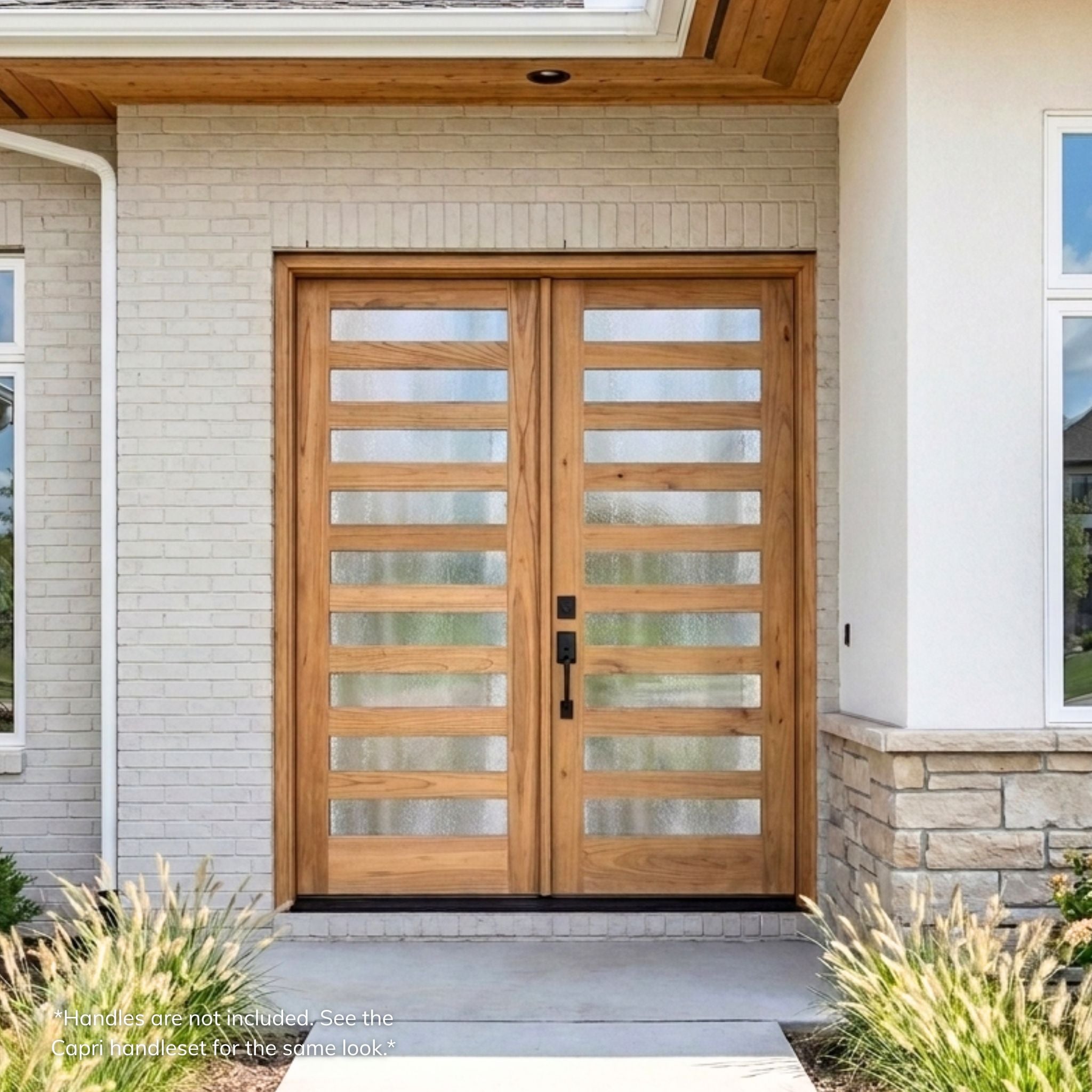 Weathercraft torrefied mahogany 9 lite double entry door with textured chinchilla glass, natural wood grain and black handleset installed on a modern white brick and stone home