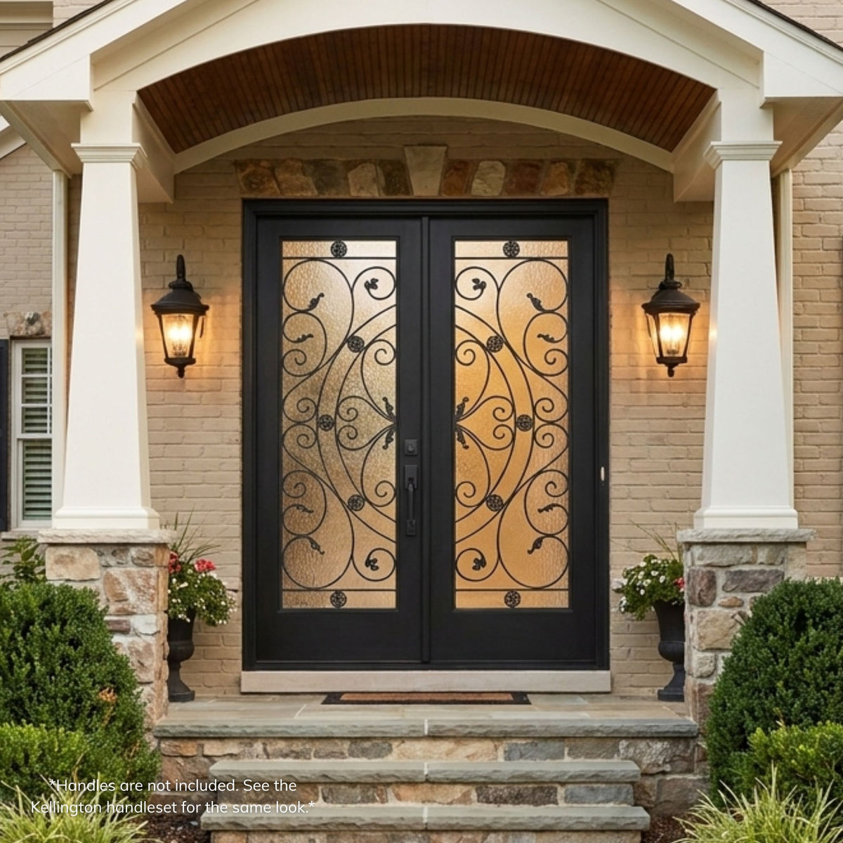 Westrock fiberglass double entry door in a black finish with full-lite decorative glass panels featuring an ornate scrollwork and medallion design, installed under an arched portico on a stone home.