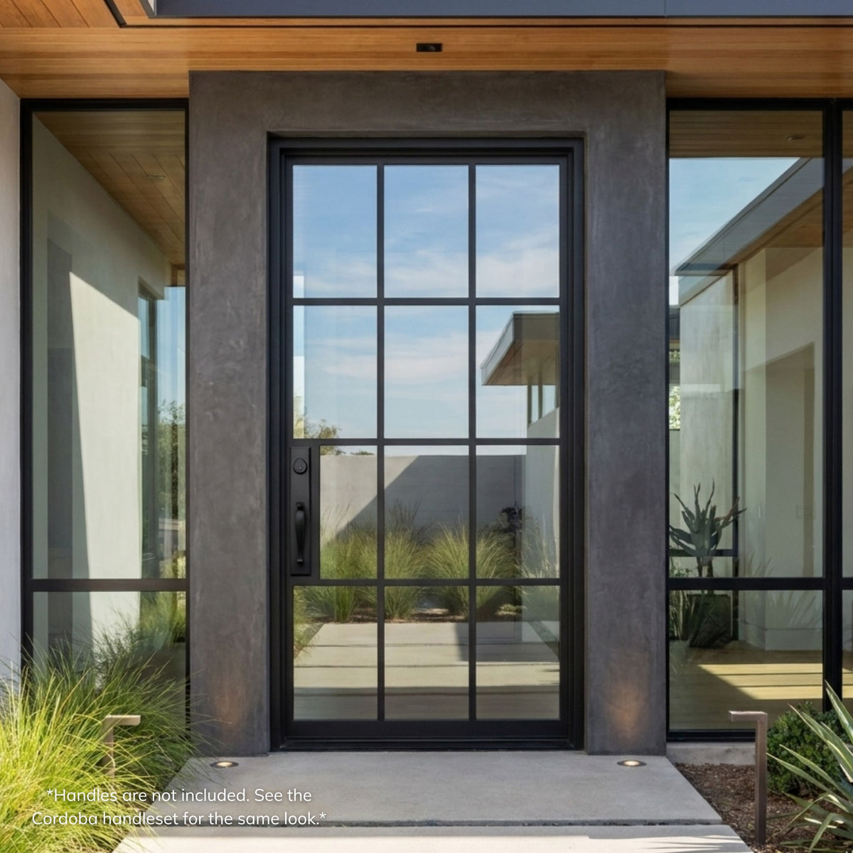 Wrought iron pivot entry door in matte black finish with a 12-lite clear glass grid, installed in a concrete pillar surround beneath a wood plank ceiling on a modern home.